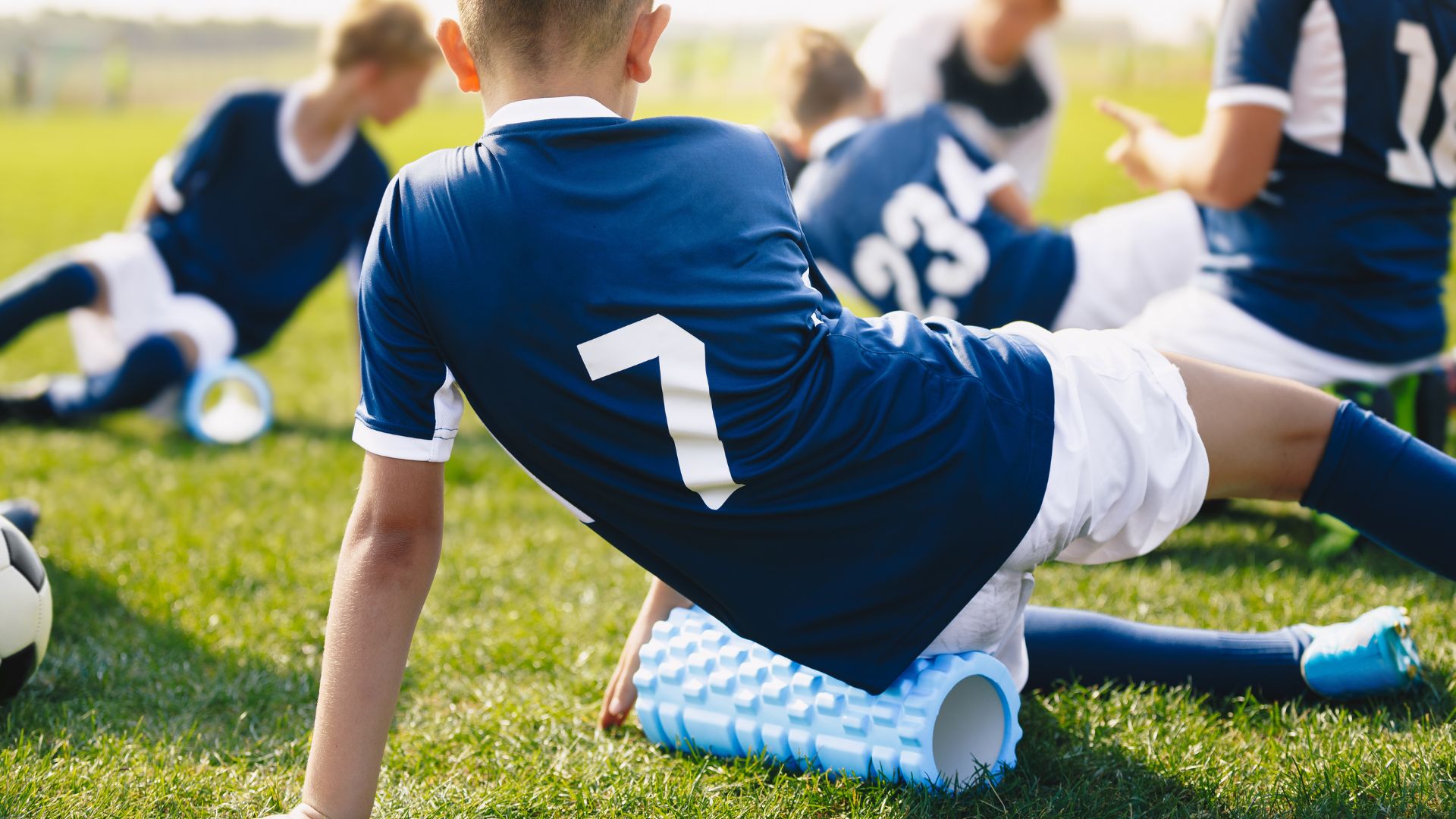 young football player using a foam roller