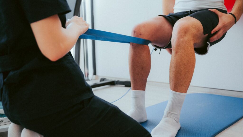physio performing assisted knee exercise