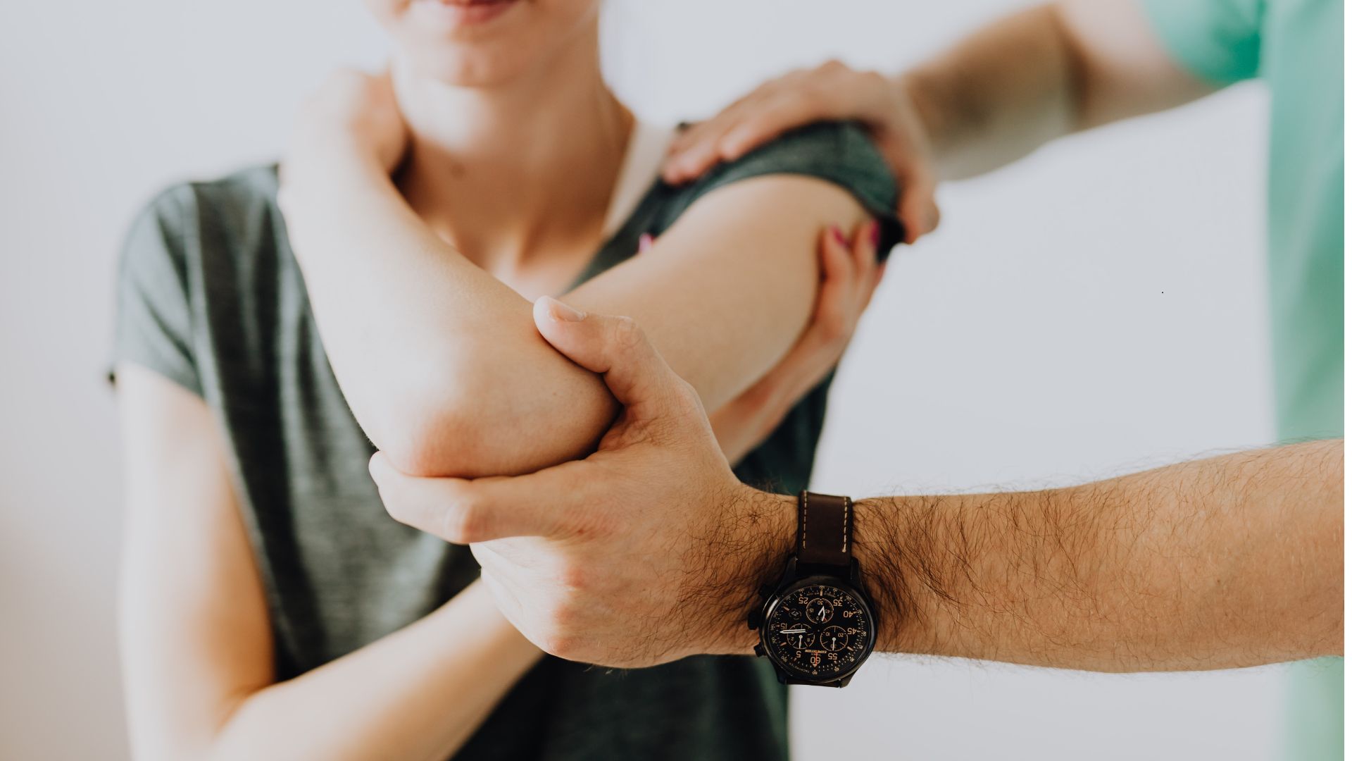 physiotherapist assessing patient's arm