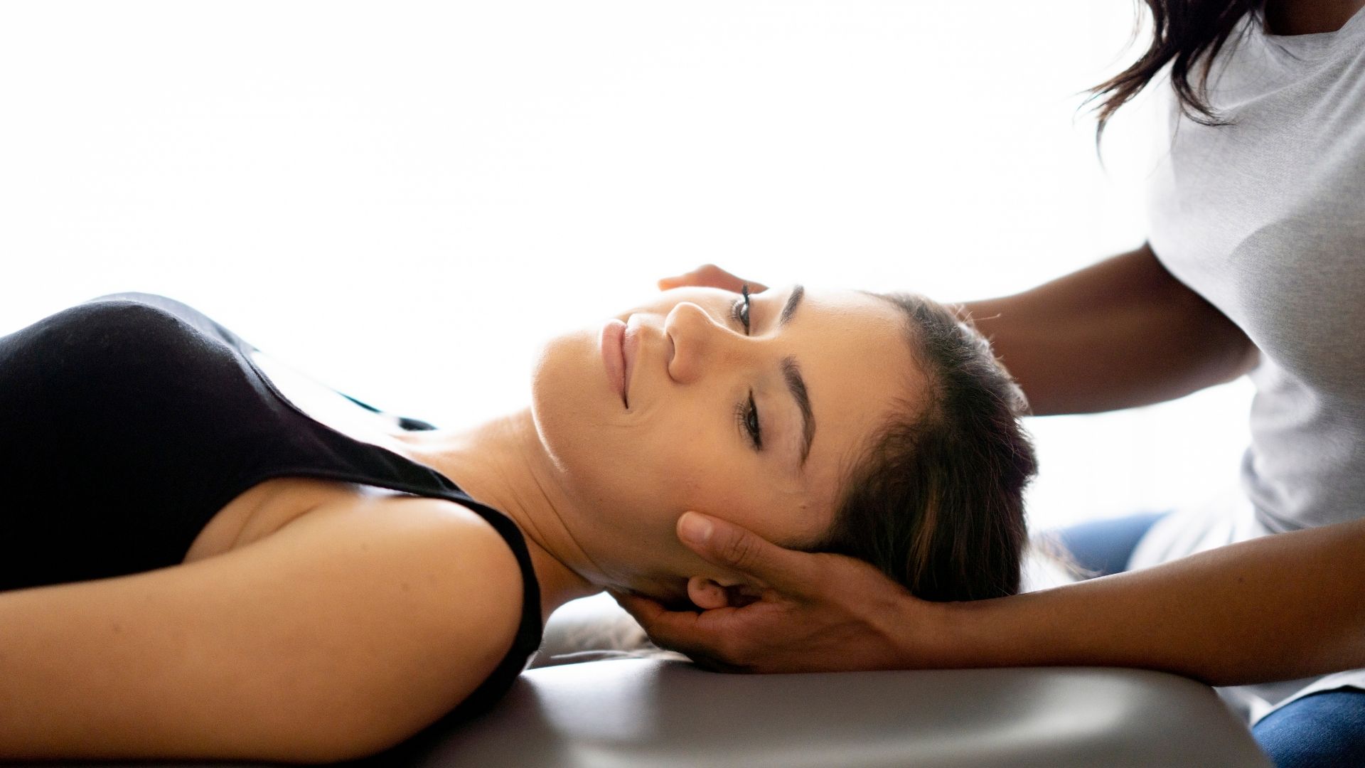 woman getting her neck adjusted at the chiropractor